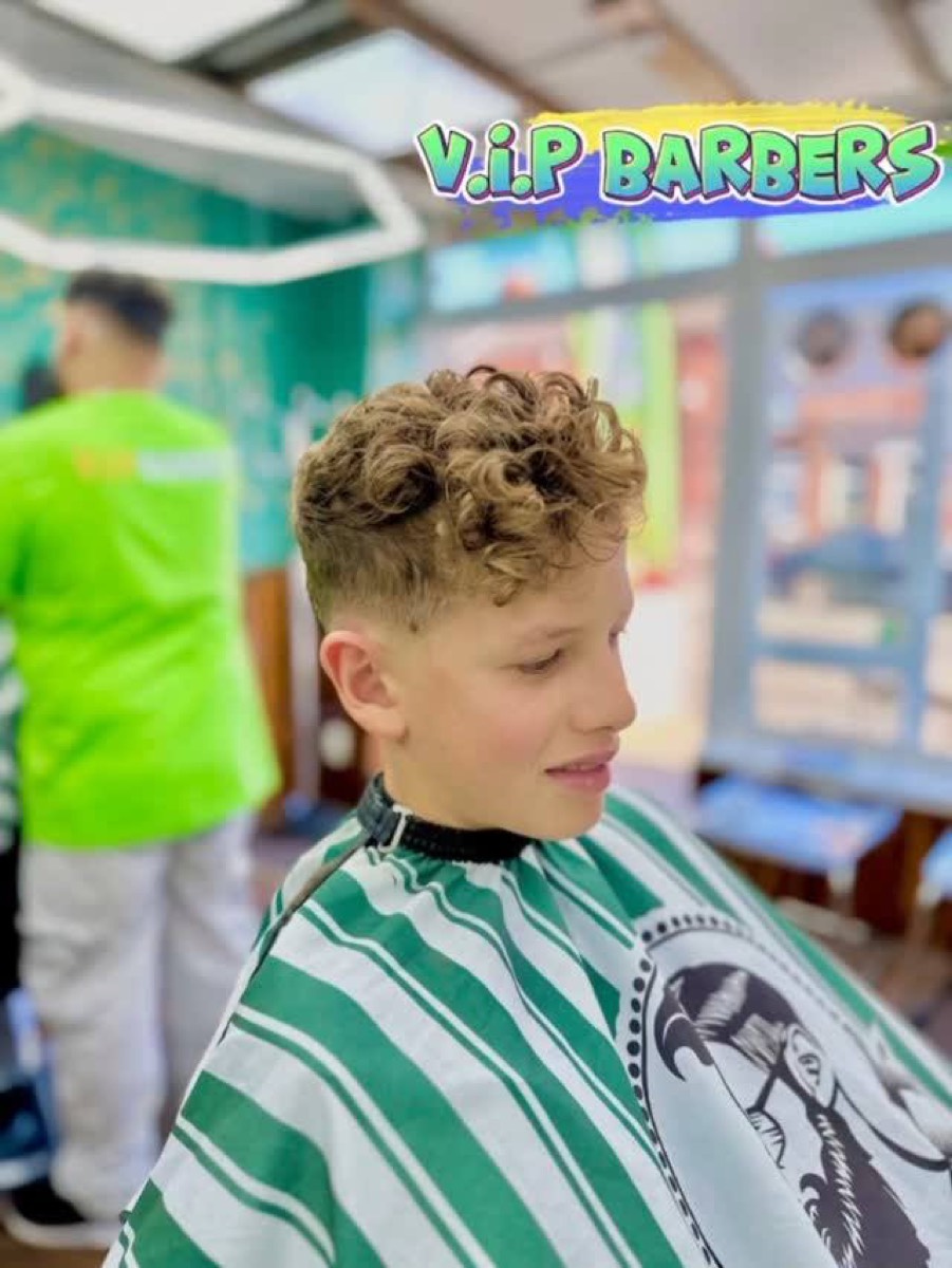 Young boy with curly hair and a fresh fade in the shop